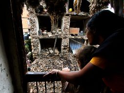 Mujer nepalesa con su hija observan a través de su ventana los escombros de un edificio colapsado. AP  /