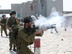 Un soldado israelí lanza gases lacrimógenos contra palestinos. AFP  /