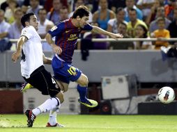 El defensa francés del Valencia CF, Adil Rami (i), intenta evitar el avance del delantero argentino Leo Messi. EFE  /