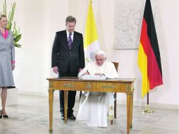 El Papa Benedicto XVI firma el libro de visitas del Bundestag (Parlamento federal) alemán. Lo observa el presidente alemán. EFE  /