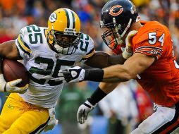 El jugador de los Empacadores Ryan Grant escapa a la marca de Brian Urlacher. EFE  /