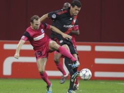 Michael Ballack (D) y Thomas Buffel del Genk pelean por el balón. EFE  /