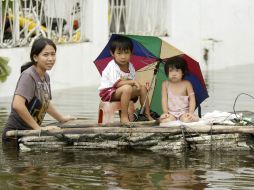 Una familia filipina afectada por el tifón Nesat en una embarcación improvisada en ''Malabón''. EFE  /