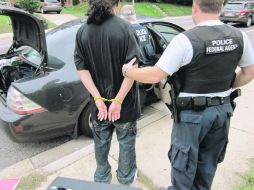 Agentes de la Oficina de Inmigración y Contro de Aduanas consignan a un indocumentado luego de la operación “Cross Check”. EFE  /