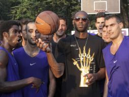 El jugador estadounidense y estrella de la NBA, Kobe Bryant (c), juega con un balón durante un acto promocional en Milán. EFE  /
