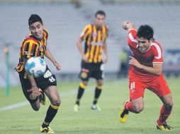 César Valdovinos disputa la pelota con Eduardo Chávez.  /