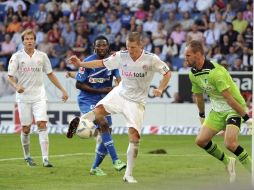 Bastian Schweinsteiger (2d), jugador del Bayern, chuta a portería ante el guardameta del Hoffenheim, Tom Starke. EFE  /