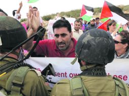 Manifestantes palestinos protestan frente a soldados israelíes en contra de la construcción de un asetamiento judío. EFE  /