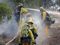 Bomberos apagan el fuego forestal en una zona rural del centro de San Diego. AP  /