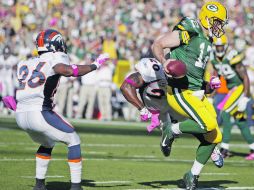 El mariscal de campo de Green Bay, Aaron Rodgers acarrea el ovoíde hasta la zona de anotación, en la victoria sobre Denver. AP  /