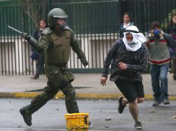 Un oficial de la policía antidisturbios intenta detener a un estudiante durante una manifestación. AFP  /
