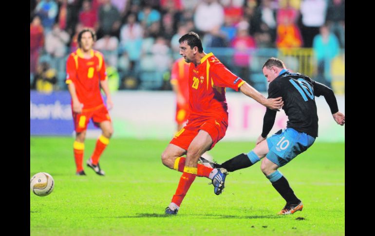 Rooney (der.) dio una patada a Miodrag Dzudovic, después de que el local hubiera frenado una acción de la estrella del Manchester. AFP  /