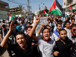 Palestinos entonan cánticos a favor de sus paisanos presos en israel, hoy, frente a la sede de la Cruz Roja en Gaza. AP  /