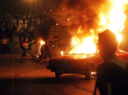 Fuerzas de seguridad egipcias se despliegan mientras vehículos arden durante una protesta de cristianos coptos en El Cairo. EFE  /