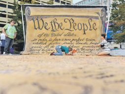 Personas firman una copia grande de la Constitución de Estados Unidos, en Washington. AFP  /