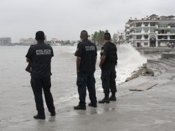 Policías municipales observan el oleaje en Puerto Vallarta, ocasionado por la tormenta tropical. EFE  /