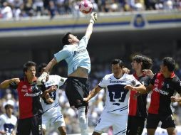 El portero de Atlas, Miguel Ángel Pinto,desvía el balón ante la marca del delantero de Pumas, Juan Carlos Cacho.EFE  /