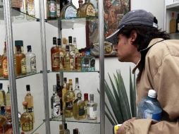 Uno de lso priemros visitantes observa atento una colección de botellas.  /