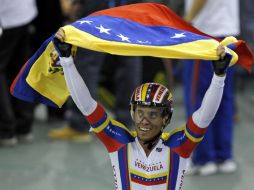 César Marcano, parte del equipo, celebra agitando una bandera de su país después de ganar. AFP  /