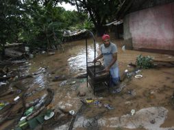 Un joven lleva una plataforma a través de las inundaciones después de fuertes lluvias en varios países de Centroamérica. REUTERS  /