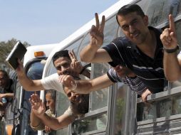 Presos palestinos excarcelados se asoman por la ventanilla del autobús que les llevó hasta el paso fronterizo con Egipto. EFE  /