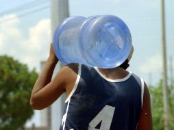 Un empleado carga un garrafón de agua. ARCHIVO  /