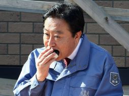 El primer ministro nipón Yoshihiko Noda, se alimenta con arroz hoy, durante su visita a Fukushima. AFP  /