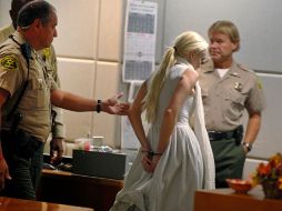 Lindsay Lohan sale esposada de la corte, al terminar la audiencia. AP  /