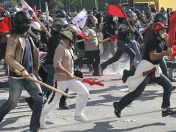 entenares de manifestantes se enfentan a agentes de la policía antidisturbios. EFE  /