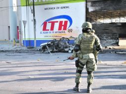 Un militar observa lo que queda del auto que estalló en la colonia Ladrillera, en Monterrey. EL UNIVERSAL  /