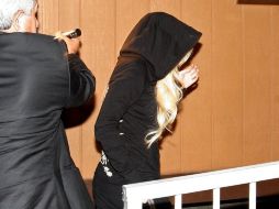 Muy rápido, incluso para los reflejos de los paparazzis, Lindsay Lohan corre a cubrir hoy su servicio comunitario. REUTERS  /