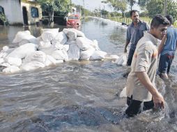 Residentes de Villa Hermosa colocan costales porque el nivel del agua sigue subiendo. EL UNIVERSAL  /