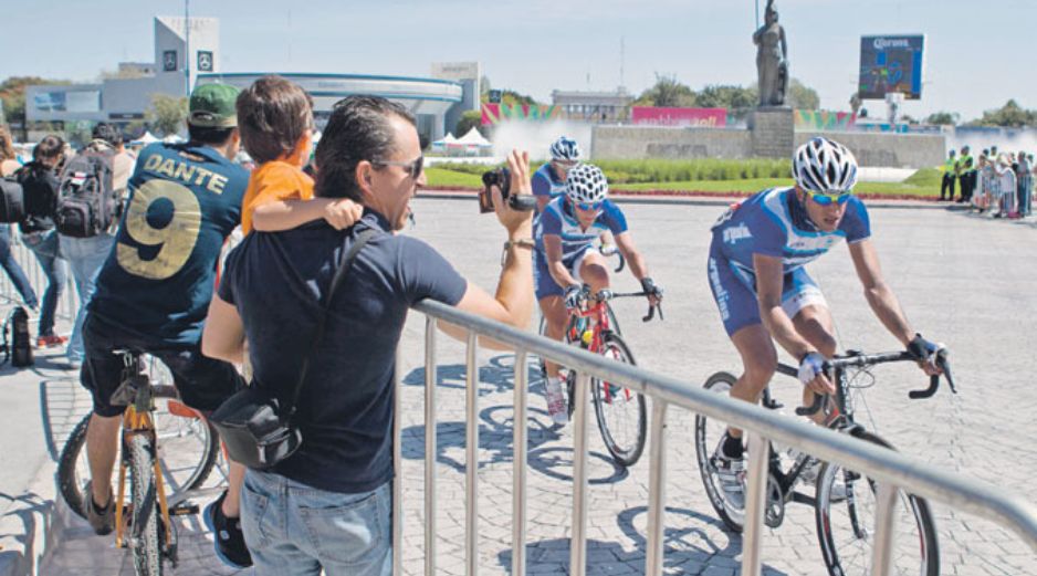 Aficionados tapatíos ven pasar a los participantes de ciclismo de ruta.  /