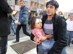 Un hombre sostiene a una menor herida tras un terremoto de 6.6 grados en Van, Turquía. EFE  /