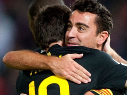 Xavi Hernández y Lionel Messi celebran el 1-0 contra Granada. AP  /