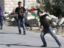 Jóvenes palestinos lanzan piedras contra policías israelíes. EFE  /