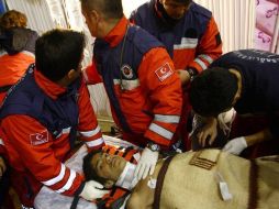 Miembros de los servicios de rescate trasladan en camilla al joven superviviente Ferhat Tokay, al este de Turquía. EFE  /