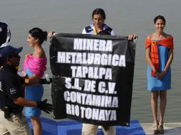 Incluso durante la protesta, a las edecanes no se les desdibujó su sonrisa. EFE  /