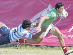 El jugador mexicano Christian Henning evade el tackleo del argentino Manuel Montero. AP  /