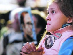 Una niña mira el juicio de los represores. usa un botón con la imagen de uno de sus parientes desaparecidos. REUTERS  /