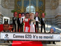 Activistas de Oxfam llevan máscaras (de izquierda a derecha) presidente ruso Dmitry Medvedev y presidente de Sudáfrica, entre otros. AP  /