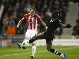 El jugador del Stoke Glenn Whelan(I) pelea por el balón con Demba Ba durante el encuentro. AP  /