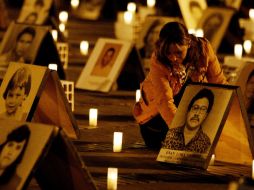 Una mujer enciende una veladora en homenaje a los desaparecidos en la Plaza Bolivar. EFE  /