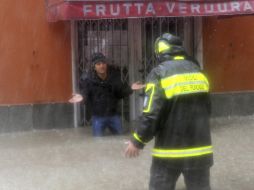 Un bombero trata de caminar en una calle inundada en Génova, Italia. EFE  /