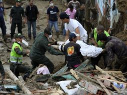 Miembros de la Policía de Colombia, la Defensa Civil, la Cruz Roja Colombiana y algunos voluntarios, rescatan una víctima. EFE  /