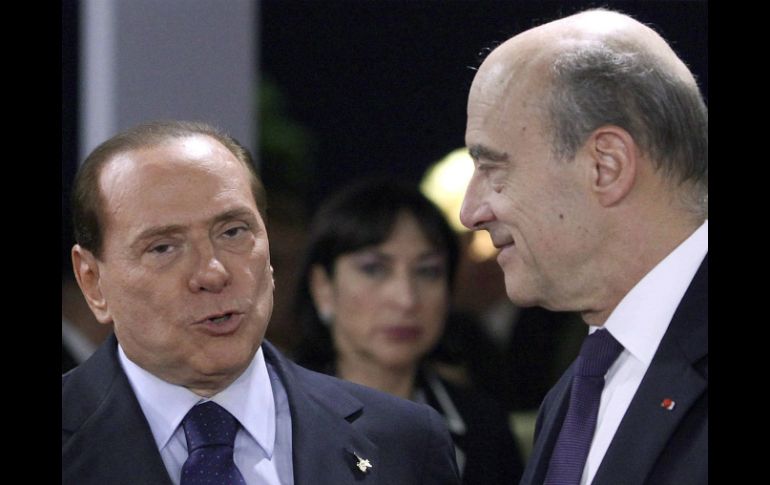El primer ministro italiano, Silvio Berlusconi (i), conversa con Alain Juppe (d), durante la cumbre del G20 en Cannes. EFE  /