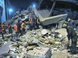 Rescatistas buscan a personas atrapadas en los edificios derrumbados. AP  /