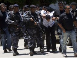 Policías escoltan al narcotraficante Antonio Bonfim, alias 'Nem', quien fue detenido hoy en la favela de Rochnha. AP  /