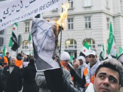 Un manifestante quema una fotografía  del presidente sirio Bashar al Assad, durante una protesta contra el régimen de Damasco. AP  /
