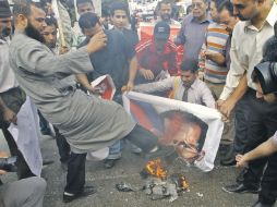 Opositores destruyen imágenes del presidente Bashar al Assad, en una protesta en Egipto. AP  /